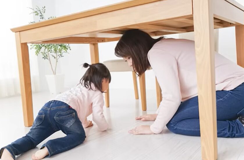 テーブルの下に隠れる親子