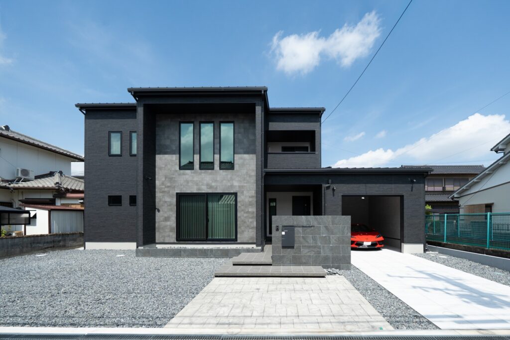 黒の邸宅で暮らす、ガレージと吹き抜けが彩るホテルライクな住まい